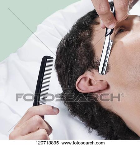 Stock Photography - Man receiving a haircut in a salon. Fotosearch