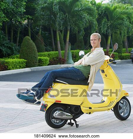Man reclining on a moped, Biltmore Hotel, Coral Gables, Florida, USA View Large Photo Image Picture - Man reclining on a moped, Biltmore Hotel, Coral Gables, Florida, USA. Fotosearch