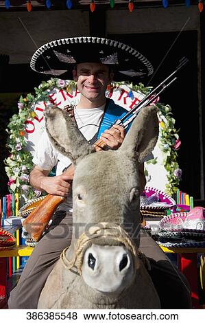 Man riding a stuffed donkey and holding a gun, Olvera Street, Los Angeles, California, USA View Large Photo Image Stock Photo - Man riding a stuffed donkey and holding a gun, Olvera Street, Los Angeles, California, USA. Fotosearch