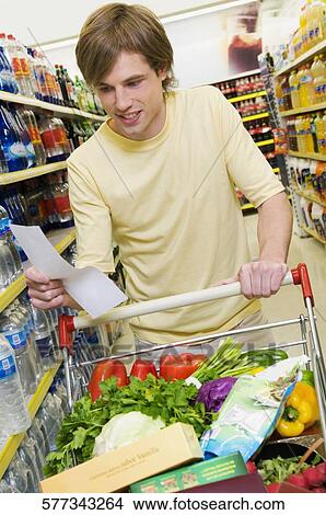 Man shopping in a supermarket View Large Photo Image Picture - Man shopping in a supermarket. Fotosearch
