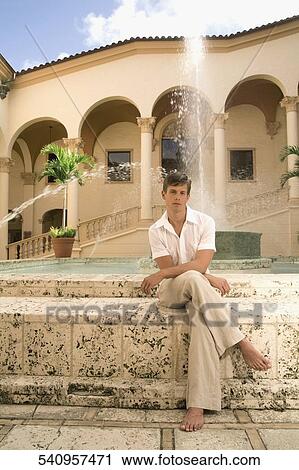 Stock Image - Man sitting in front of a fountain, Biltmore Hotel, Coral Gables, Florida, USA. Fotosearch