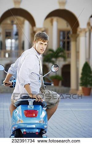 Man sitting on a moped, Biltmore Hotel, Coral Gables, Florida, USA View Large Photo Image Picture - Man sitting on a moped, Biltmore Hotel, Coral Gables, Florida, USA. Fotosearch
