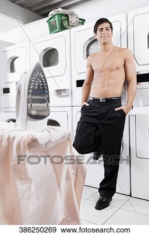 Man standing in a laundromat View Large Photo Image Stock Photo - Man standing in a laundromat. Fotosearch