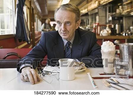 Stock Image - Man thinking in a restaurant. Fotosearch