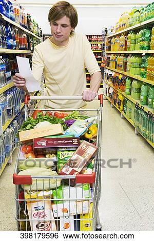Man with a shopping cart and a shopping list View Large Photo Image Stock Photograph - Man with a shopping cart and a shopping list. Fotosearch