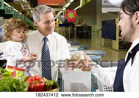 Man with his grandson paying to sales clerk at a checkout counter View Large Photo Image Stock Image - Man with his grandson paying to sales clerk at a checkout counter. Fotosearch