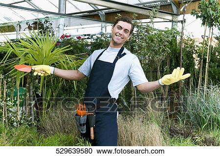 Man working in a greenhouse View Large Photo Image Stock Image - Man working in a greenhouse. Fotosearch