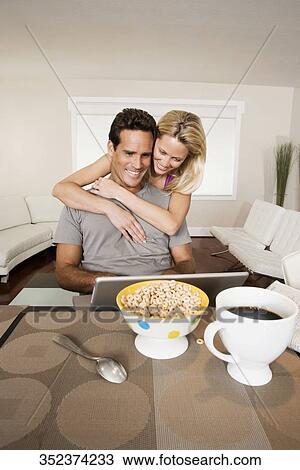 Man working on a laptop and a woman hugging him from behind View Large Photo Image Stock Image - Man working on a laptop and a woman hugging him from behind. Fotosearch