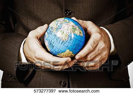 Mid section view of a businessman holding a globe View Large Photo Image Stock Photo - Mid section view of a businessman holding a globe. Fotosearch