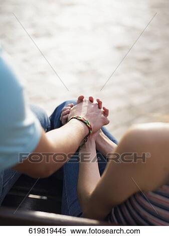 Mid section view of a couple sitting together and holding hands View Large Photo Image Stock Photography - Mid section view of a couple sitting together and holding hands. Fotosearch
