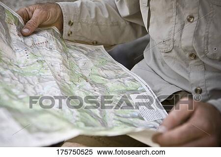 Stock Photography - Mid section view of a hiker holding a map. Fotosearch