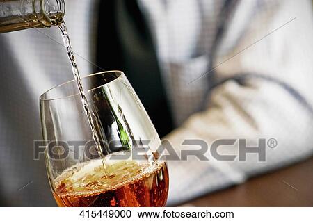 Mid section view of a man pouring red wine into a wine glass View Large Photo Image Stock Image - Mid section view of a man pouring red wine into a wine glass. Fotosearch