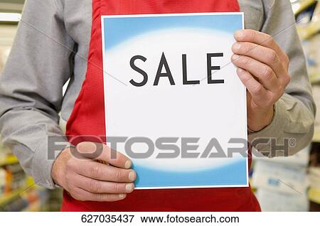 Mid section view of a salesman holding a Sale sign View Large Photo Image Stock Photo - Mid section view of a salesman holding a Sale sign. Fotosearch