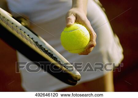 Stock Image - Mid section view of a woman playing tennis. Fotosearch