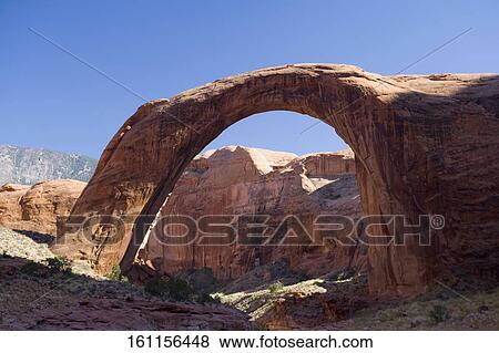 Stock Photo - Natural arch on an arid landscape, Rainbow arch, Lake Powell, Rainbow Bridge National Monument, Glen Canyon National Recreation Area, Utah, USA. Fotosearch