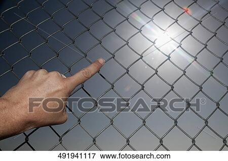 Person pointing towards the sun through chainlink fence View Large Photo Image Stock Photo - Person pointing towards the sun through chainlink fence. Fotosearch