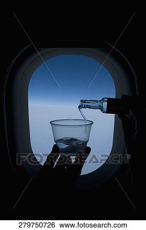 Person pouring whiskey into a glass in front of an airplane window View Large Photo Image Stock Photograph - Person pouring whiskey into a glass in front of an airplane window. Fotosearch
