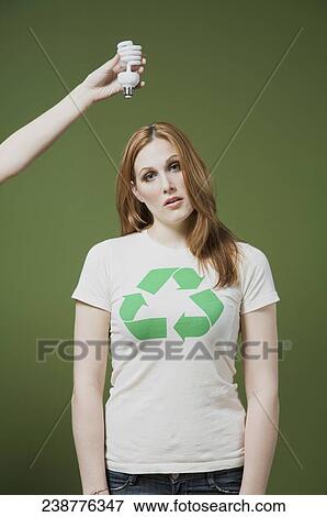Stock Photo - Person's hand holding a light bulb above a woman's head. Fotosearch