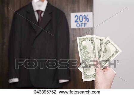 Person's hand holding currency notes in a clothing store View Large Photo Image Stock Image - Person's hand holding currency notes in a clothing store. Fotosearch