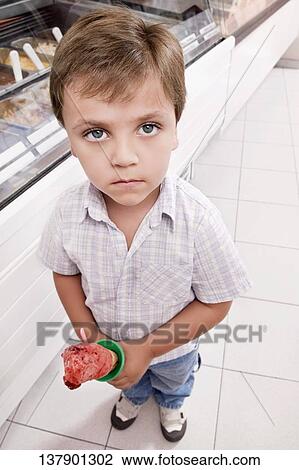 Portrait of a boy holding an ice cream View Large Photo Image Stock Image - Portrait of a boy holding an ice cream. Fotosearch