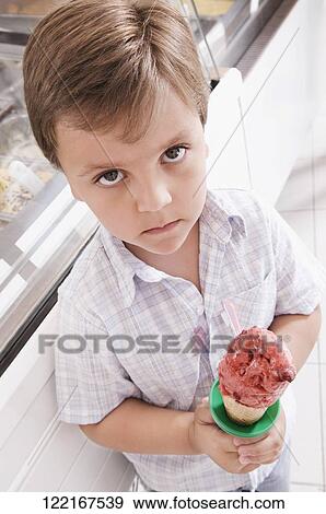 Portrait of a boy holding an ice cream View Large Photo Image Stock Photo - Portrait of a boy holding an ice cream. Fotosearch