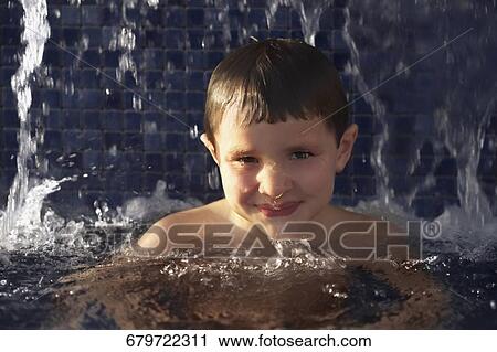 Stock Image - Portrait of a boy in a swimming pool. Fotosearch