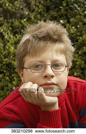 Stock Photo - Portrait of a boy with his hand on his chin. Fotosearch