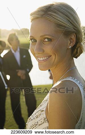 Portrait of a bride smiling with two golfers in the background, Biltmore Golf Course, Coral Gables, Florida, USA View Large Photo Image Stock Photo - Portrait of a bride smiling with two golfers in the background, Biltmore Golf Course, Coral Gables, Florida, USA. Fotosearch