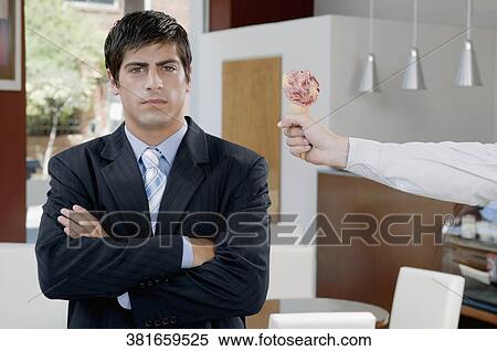 Stock Photography - Portrait of a businessman in an ice cream parlor. Fotosearch