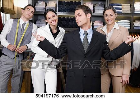 Stock Photograph - Portrait of a businessman with two saleswomen and a tailor in a store. Fotosearch