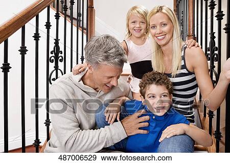 Stock Photo - Portrait of a family smiling on a staircase. Fotosearch