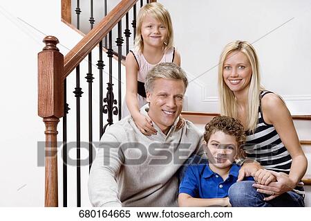 Portrait of a family smiling on a staircase View Large Photo Image Stock Photography - Portrait of a family smiling on a staircase. Fotosearch