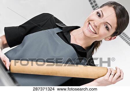 Portrait of a female chef holding a rolling pin and smiling View Large Photo Image Picture - Portrait of a female chef holding a rolling pin and smiling. Fotosearch