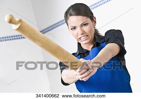 Portrait of a female chef holding a rolling pin and clenching her teeth View Large Photo Image Stock Image - Portrait of a female chef holding a rolling pin and clenching her teeth. Fotosearch