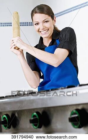 Portrait of a female chef holding a rolling pin and smiling View Large Photo Image Stock Image - Portrait of a female chef holding a rolling pin and smiling. Fotosearch