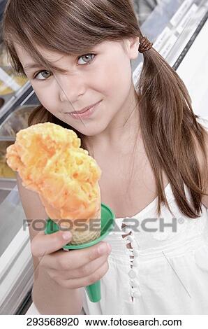 Stock Image - Portrait of a girl holding an ice cream. Fotosearch