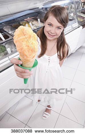 Portrait of a girl holding an ice cream View Large Photo Image Stock Photo - Portrait of a girl holding an ice cream. Fotosearch
