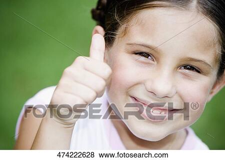 Portrait of a girl smiling and showing a thumbs up sign View Large Photo Image Stock Photo - Portrait of a girl smiling and showing a thumbs up sign. Fotosearch
