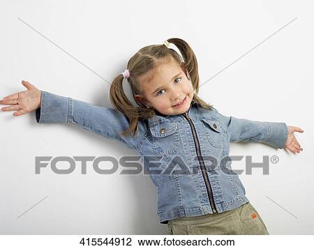 Portrait of a girl standing against a wall and smiling View Large Photo Image Stock Image - Portrait of a girl standing against a wall and smiling. Fotosearch