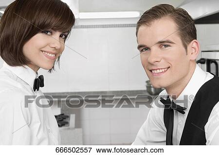 Portrait of a male and a female waiters smiling View Large Photo Image Stock Photo - Portrait of a male and a female waiters smiling. Fotosearch