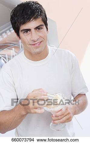 Portrait of a man eating an ice cream View Large Photo Image Picture - Portrait of a man eating an ice cream. Fotosearch