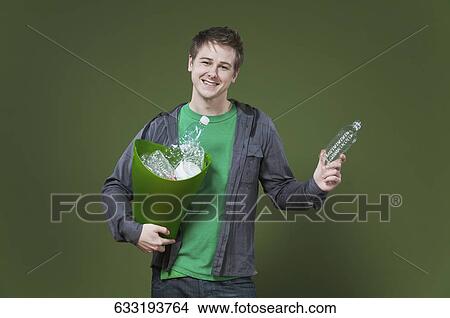Portrait of a man holding a recycling bin and smiling View Large Photo Image Picture - Portrait of a man holding a recycling bin and smiling. Fotosearch