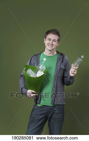 Portrait of a man holding a recycling bin and smiling View Large Photo Image Stock Image - Portrait of a man holding a recycling bin and smiling. Fotosearch