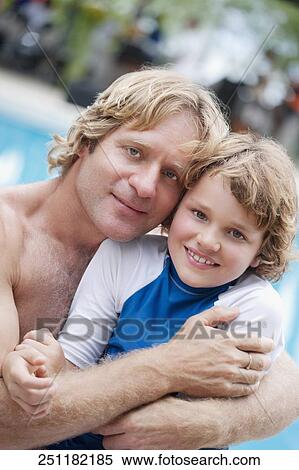 Stock Photography - Portrait of a man hugging his son at the poolside. Fotosearch