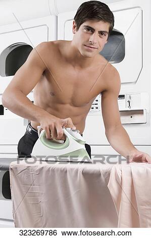 Stock Photograph - Portrait of a man ironing a shirt. Fotosearch