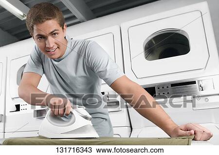 Portrait of a man ironing a t-shirt View Large Photo Image Stock Image - Portrait of a man ironing a t-shirt. Fotosearch