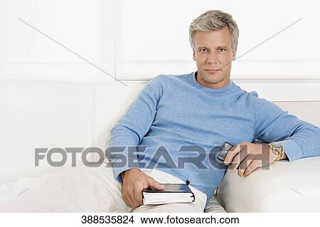 Portrait of a man reclining on a couch View Large Photo Image Picture - Portrait of a man reclining on a couch. Fotosearch