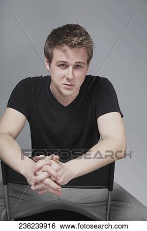 Stock Photograph - Portrait of a man sitting on a chair. Fotosearch