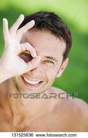 Portrait of a mid adult man smiling and making an ok sign View Large Photo Image Stock Photograph - Portrait of a mid adult man smiling and making an ok sign. Fotosearch