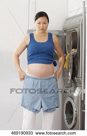Portrait of a pregnant woman holding shorts View Large Photo Image Stock Image - Portrait of a pregnant woman holding shorts. Fotosearch